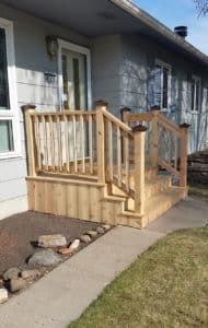Custom-built front porch, railing & steps leading off the side of a house