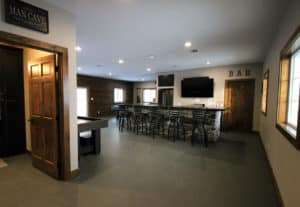Wide angle view of newly remodeled man cave with bar, bathroom, pool table & shuffleboard
