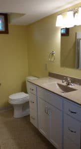 Upgraded bathroom remodel with yellow walls and white cabinets