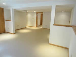 Bright, white-walled & light wood baseboard trim basement