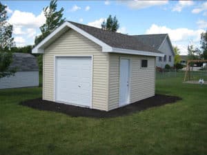 Cute beige backyard shed with white door & small white garage door