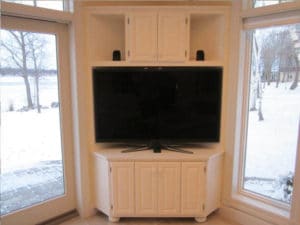 Custom white floor-to-ceiling TV stand built in with cabinets