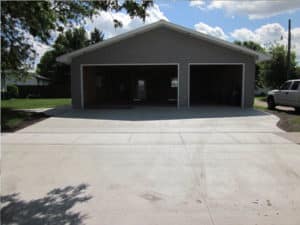 Large grey garage with 1 large garage door and 1 smaller garage door