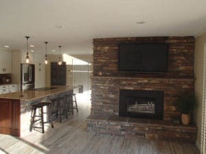 Large custom stonework fireplace & matching kitchen island