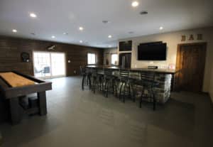 Remodeled ‘man cave’ with view of custom bar and shuffleboard table
