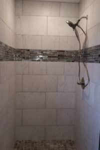 Large white ceramic tiled shower with thin shiny tile surround feature