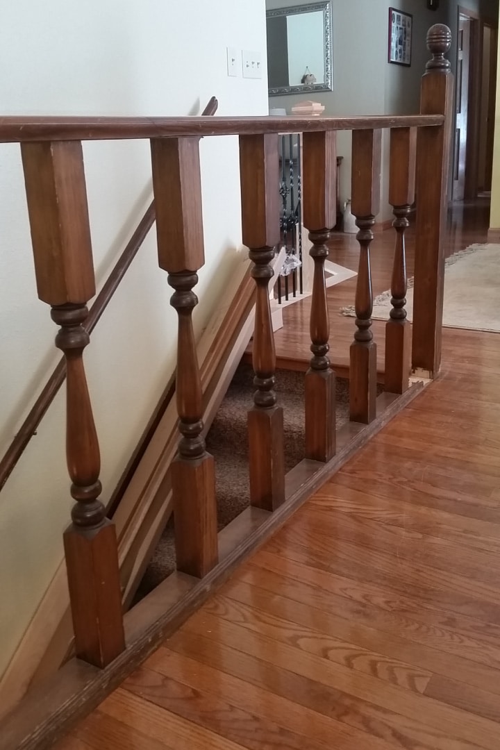 'Before’ picture of scratched, worn-down, dark-brown stair railing