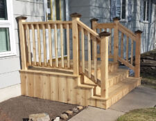 Custom-built front porch, railing & steps leading off the side of a house