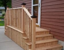 Small wooden porch off with two sets of stairs & railing