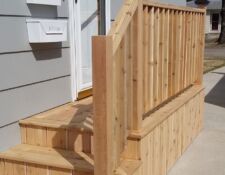 Light wooden small side porch with two steps & railing