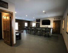Wide angle view of newly remodeled man cave with bar, bathroom, pool table & shuffleboard