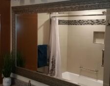 Bathroom remodel with grey speckled countertop & clean beige tiled shower