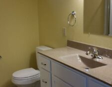 Upgraded bathroom remodel with yellow walls and white cabinets