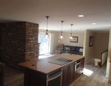 Large kitchen island looking towards custom fireplace & living area