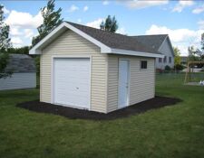Cute beige backyard shed with white door & small white garage door