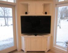 Custom white floor-to-ceiling TV stand built in with cabinets
