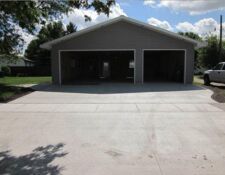 Large grey garage with 1 large garage door and 1 smaller garage door