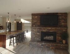Large custom stonework fireplace & matching kitchen island