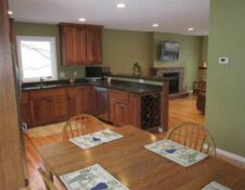 Remodeled kitchen with green walls wood cabinets & black counters