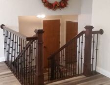 Dark wood stairs & railing with wrought-iron decorative details