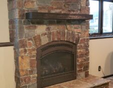 Custom floor-to-ceiling red, grey & beige large mixed stone fireplace