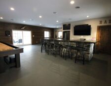 Remodeled ‘man cave’ with view of custom bar and shuffleboard table